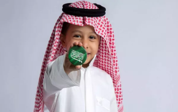 صورة لطفل يحمل علم السعودية