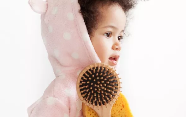 صورة لطفل يحمل فرشاة الشعر