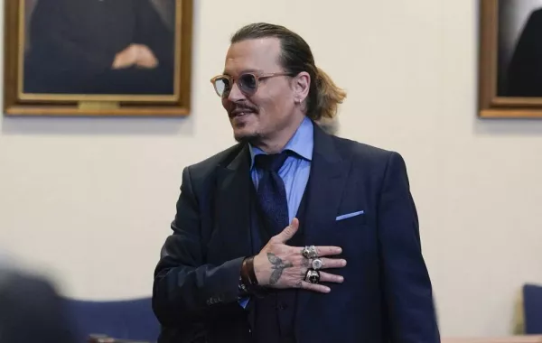 Actor Johnny Depp gestures to spectators in court after closing arguments at the Fairfax County Circuit Courthouse in Fairfax, Virginia, on May 27, 2022. Actor Johnny Depp is suing ex-wife Amber Heard for libel after she wrote an op-ed piece in The Washington Post in 2018 referring to herself as a “public figure representing domestic abuse.” Steve Helber / POOL / AFP